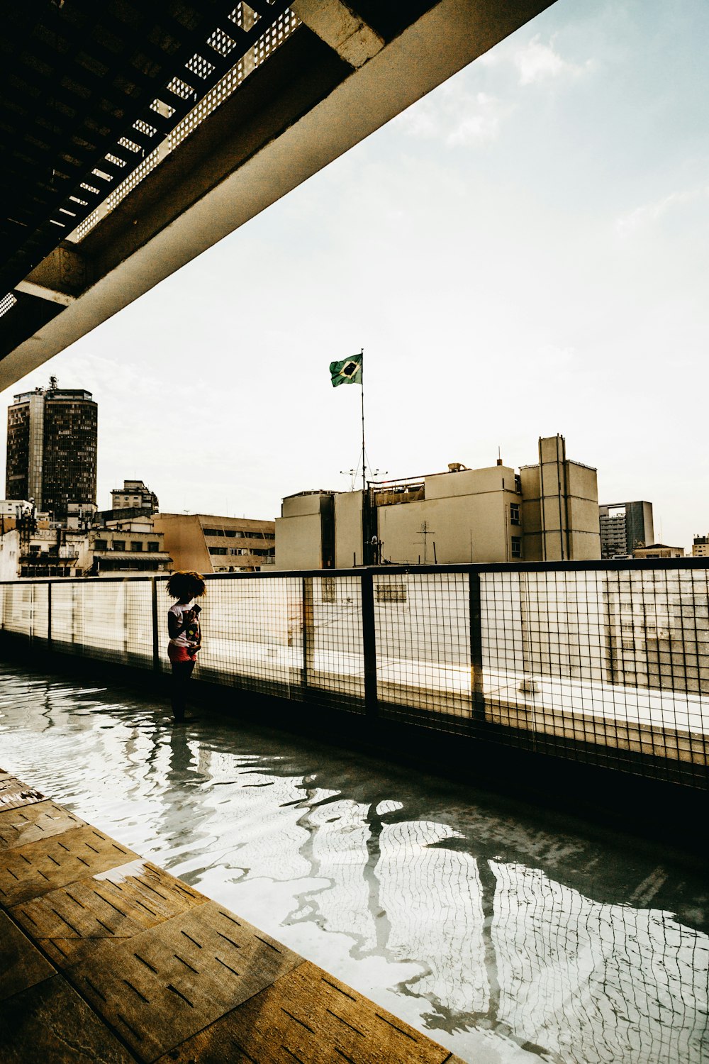 Una persona parada en un puente sobre un cuerpo de agua