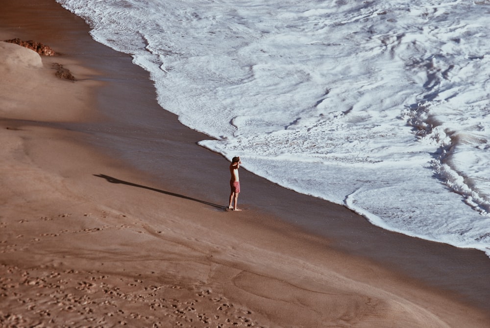 person standing on seashore during daytime