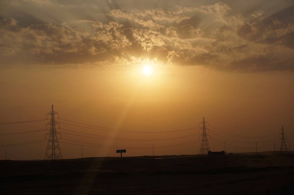 black power lines under orange and gray skies