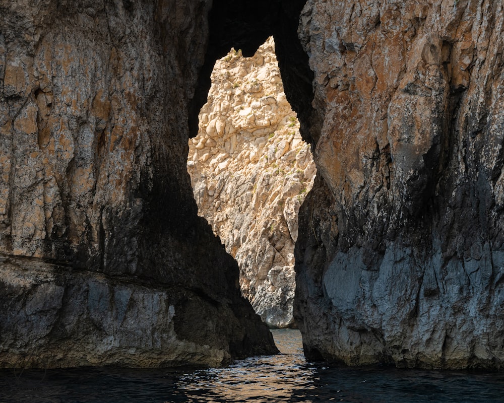 brown and black rock formation and body of water