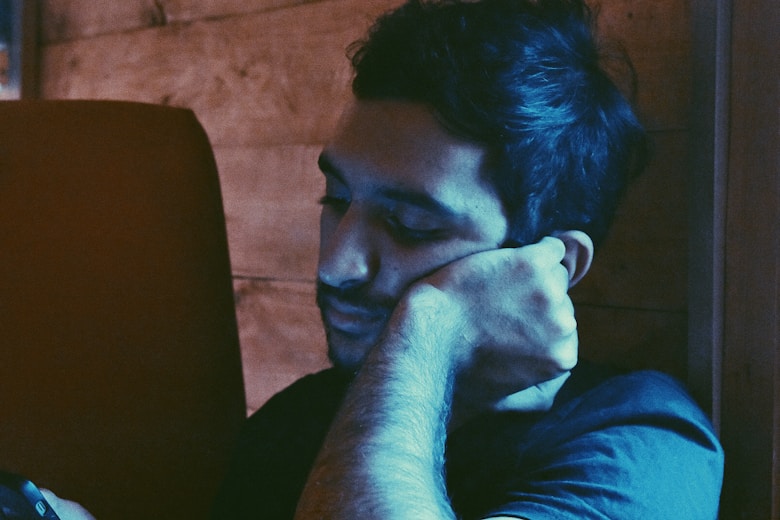 man leaning his face on his left hand