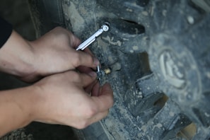 A Sustur team member checking tire pressure on a vehicle