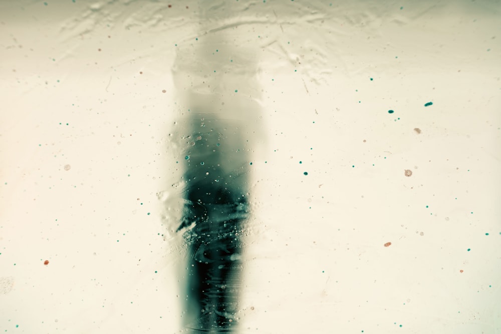 Una foto in bianco e nero di una persona in piedi sotto la pioggia