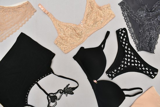 Various types of lingerie are displayed on a light gray background, including lace bras and bralettes in nude and gray, along with black bras featuring different designs.