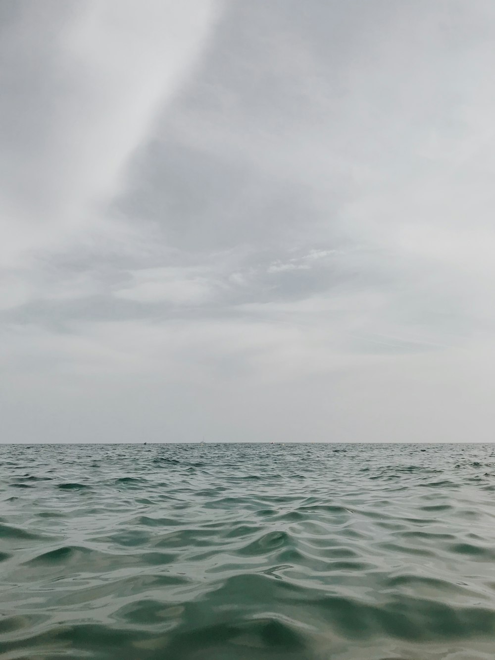 a body of water with a cloudy sky above it