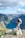 man standing on rock looking towards lake