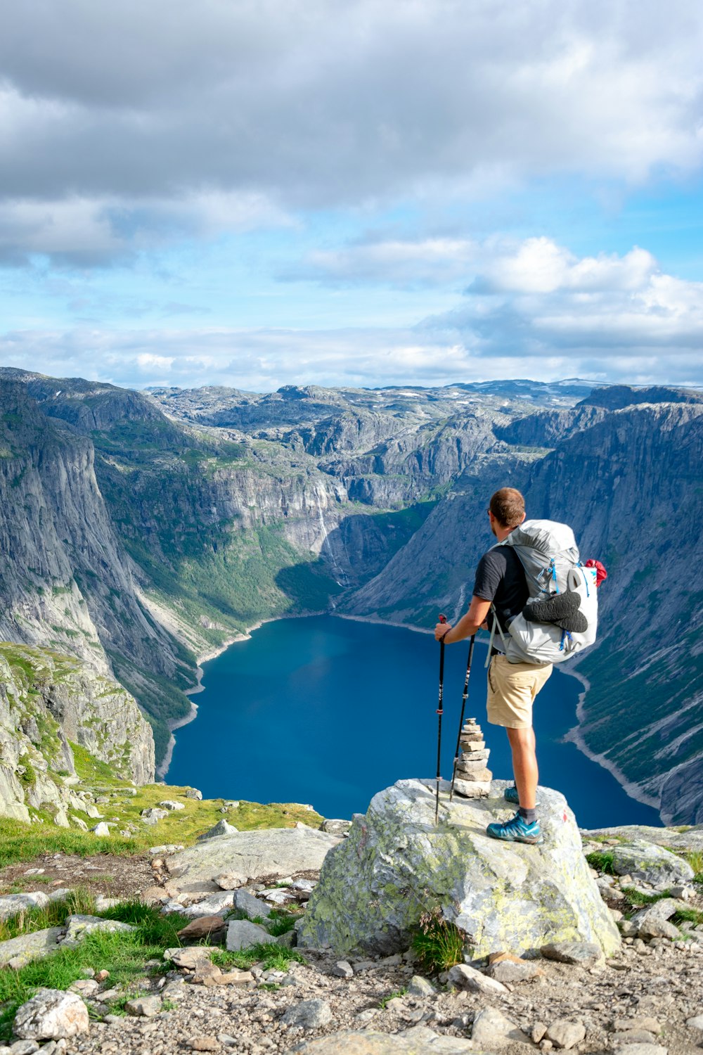 homme debout sur le rocher regardant vers le lac