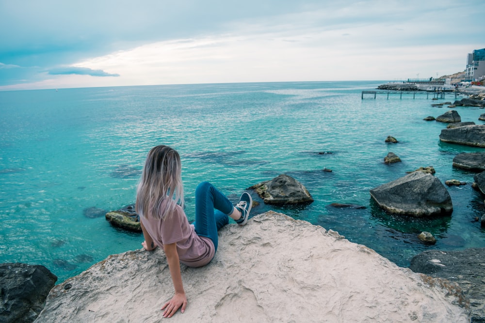 woman sitting on rock