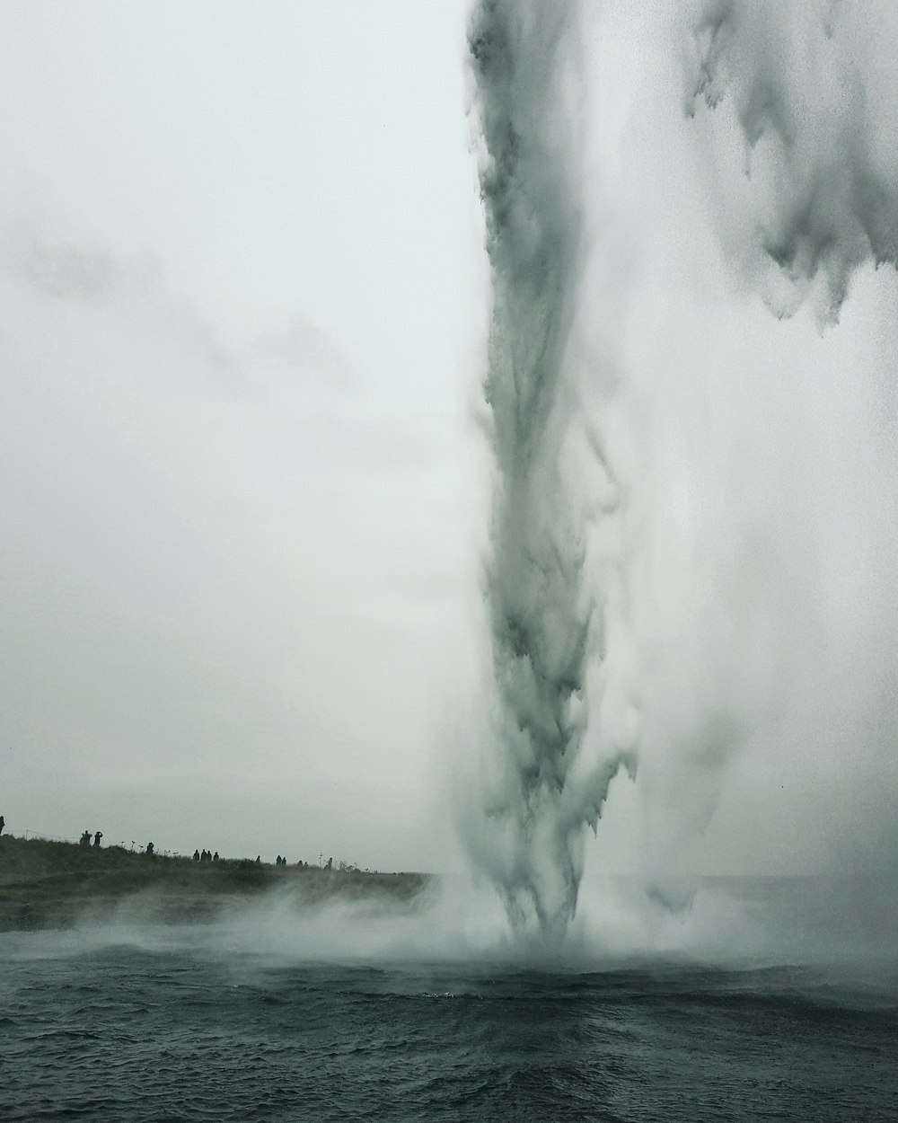 a large plume of smoke billowing out of the water