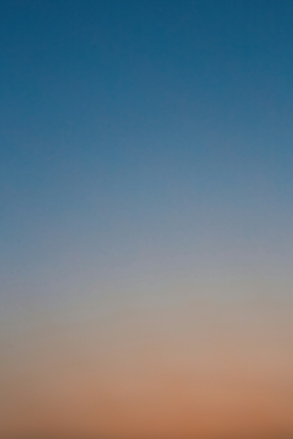 a plane flying in the sky at sunset