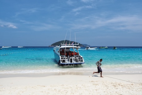 Passengers boarding a sleek speedboat at a Maldivian dock.