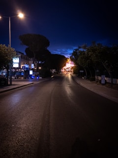 Close-up of a ujtron LED street light illuminating a quiet neighborhood street at dusk.