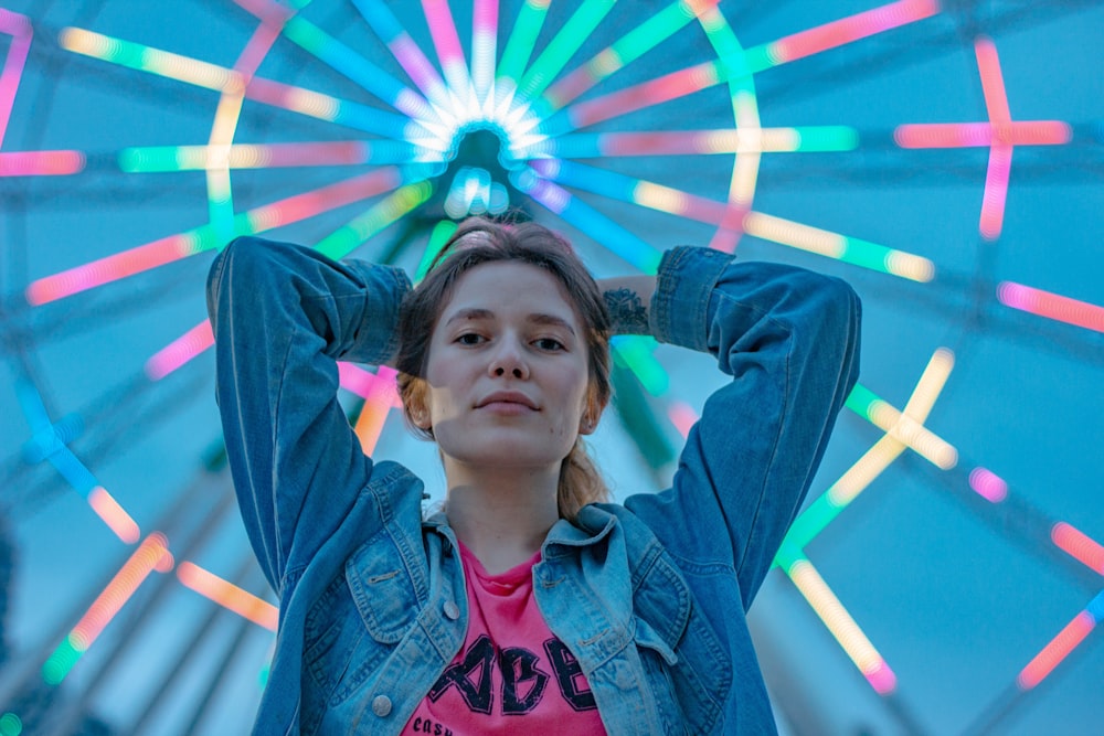 woman wearing blue denim jacket putting both hands on her head while standing