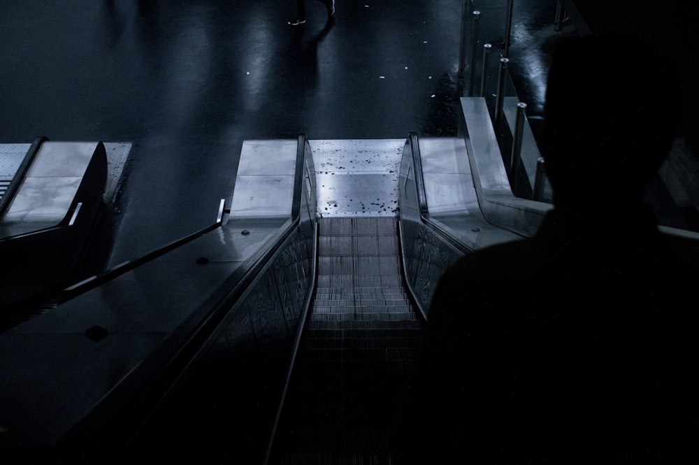 a man walking down an escalator at night