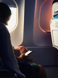 Close-up of a traveler activating an eSIM on their phone while waiting at an airport lounge.