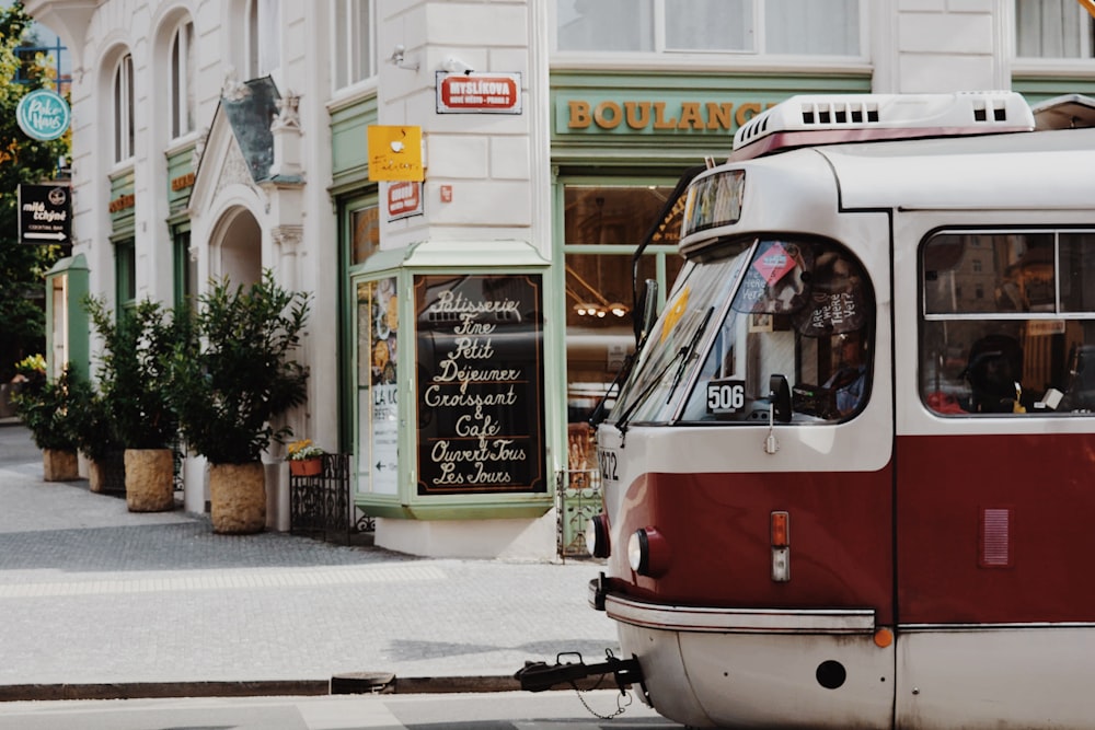 a red and white trolley on a city street