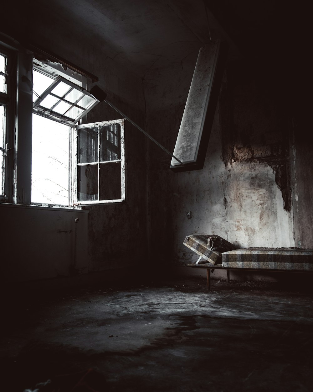 bed inside abandoned building near opened window