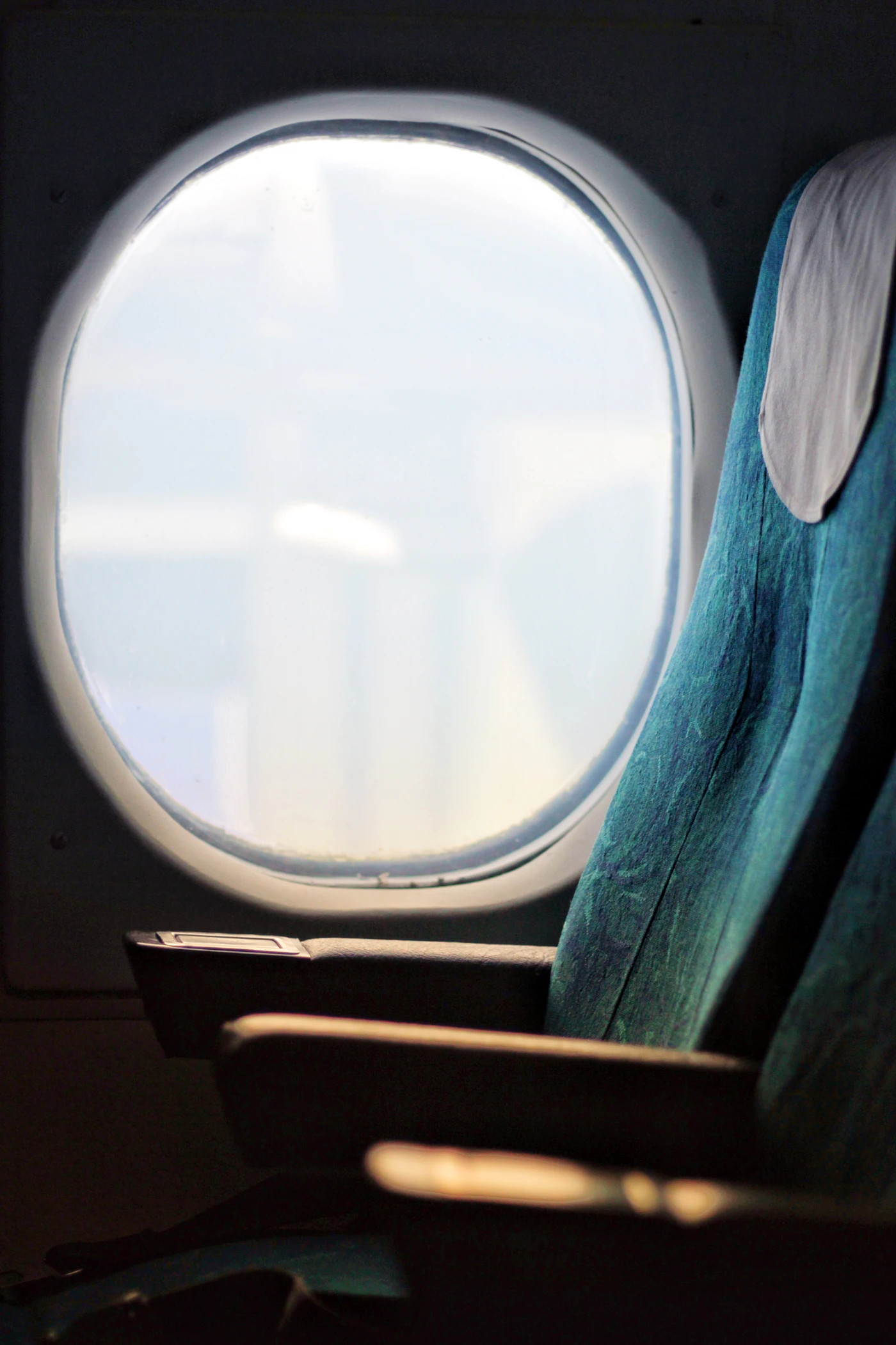 An empty window seat on an aircraft with clouds outside — the premium-cabin redemptions that transfer bonuses unlock