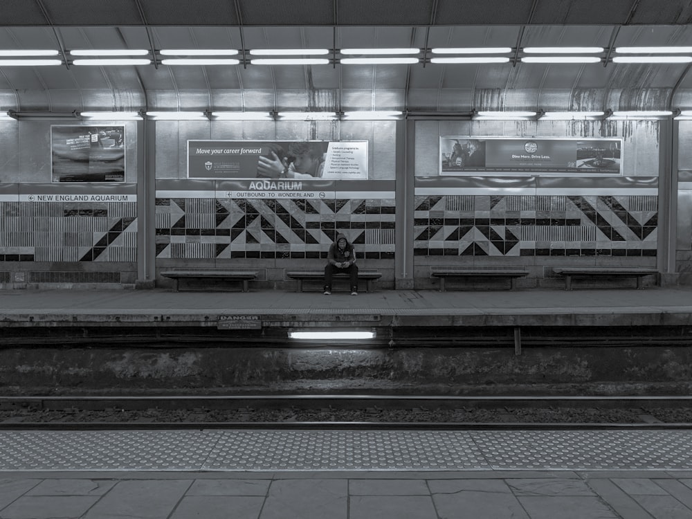 person sitting on bench at the train station