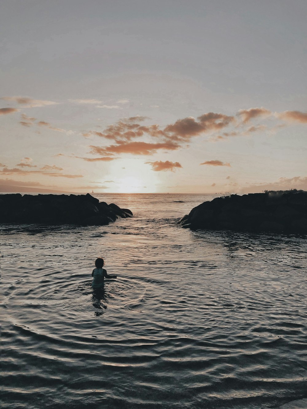 a person in a body of water at sunset