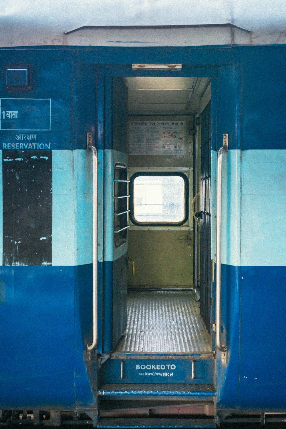 a blue and white train with the door open