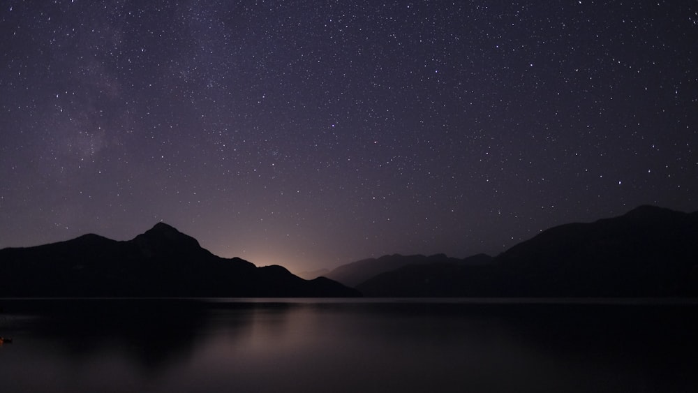 Cuerpo de agua a través de la montaña durante la noche