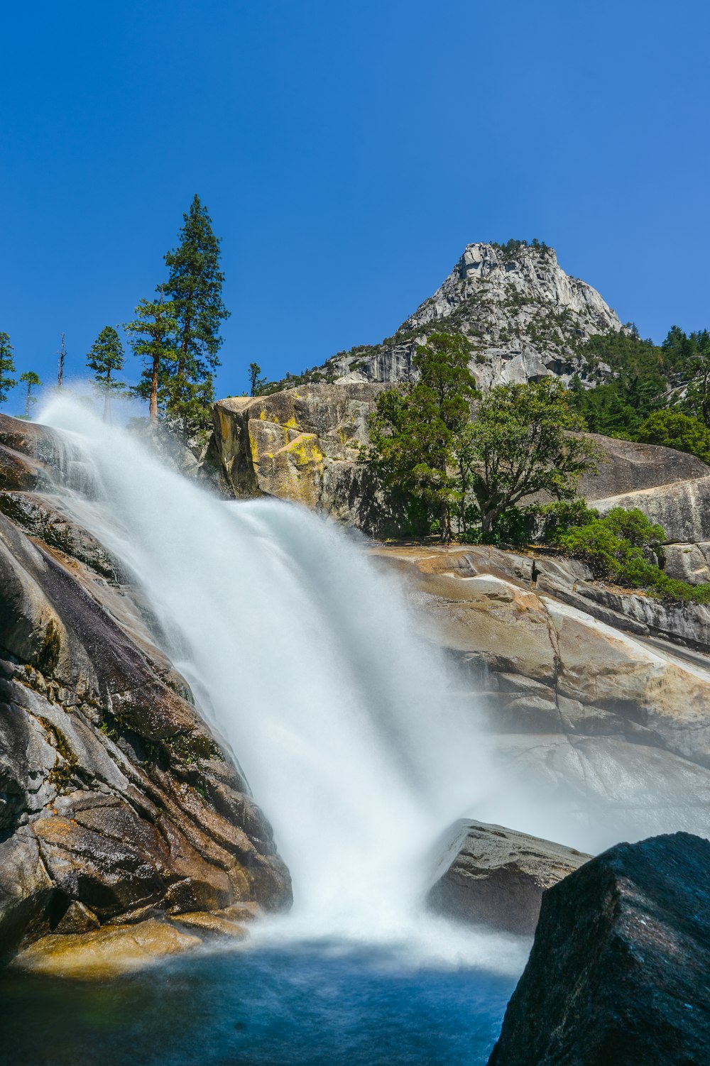 a large waterfall with a mountain in the background