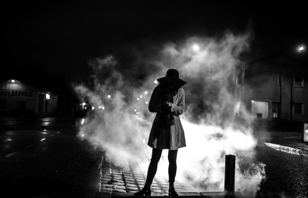 grayscale photography of woman standing on road