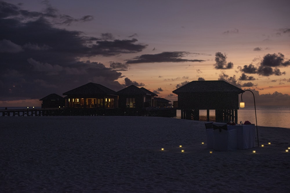 a couple of buildings sitting on top of a sandy beach