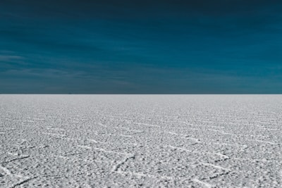 a vast expanse of snow with a blue sky in the background