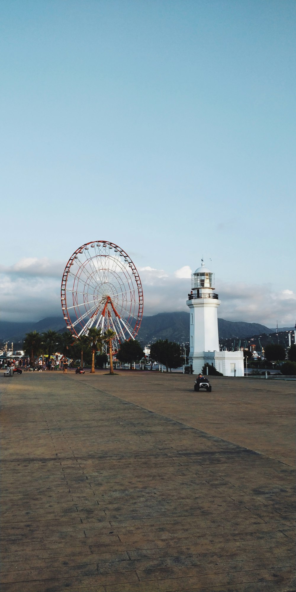 red ferris wheel near light house