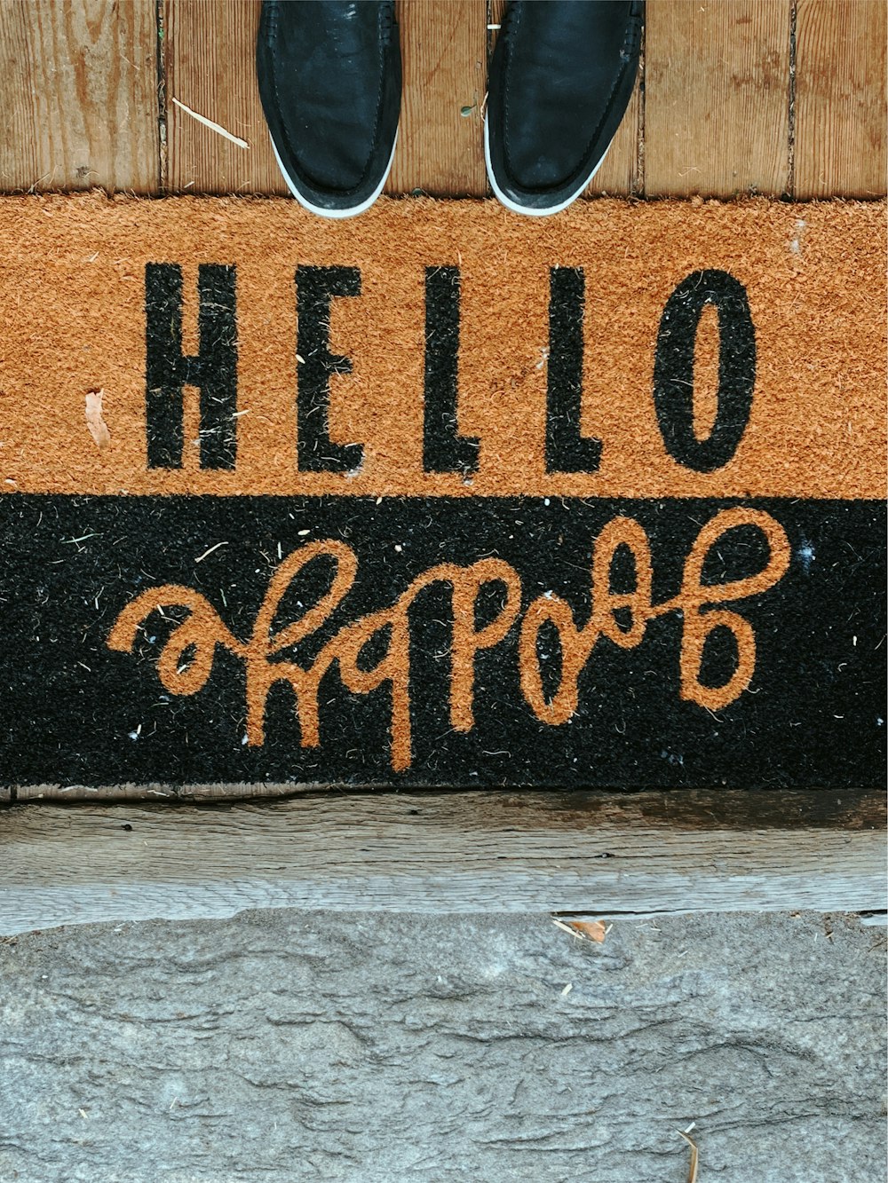 black shoes in front of black and brown Hello Goodbye area rug