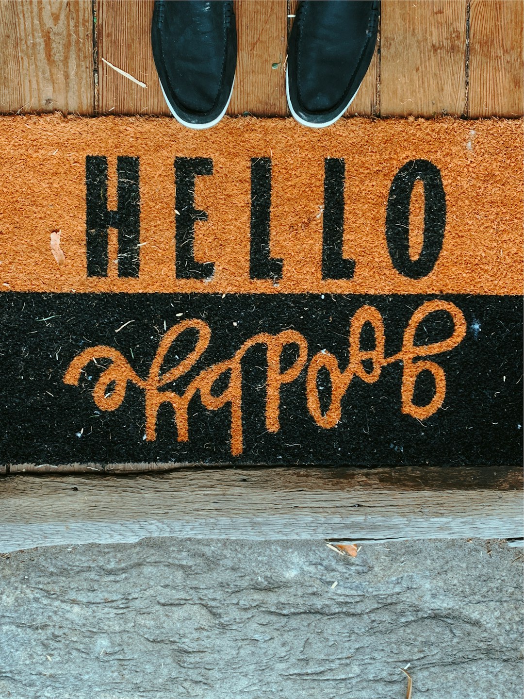  black shoes in front of black and brown hello goodbye area rug doormat