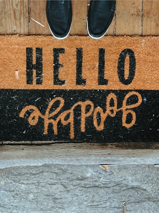 black shoes in front of black and brown Hello Goodbye area rug