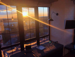 A cozy room with soft lighting, a window showing a twilight sky, and comfortable seating.