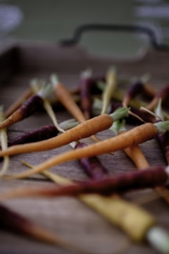 Colorful assortment of carrots and cabbage displayed on a wooden table.