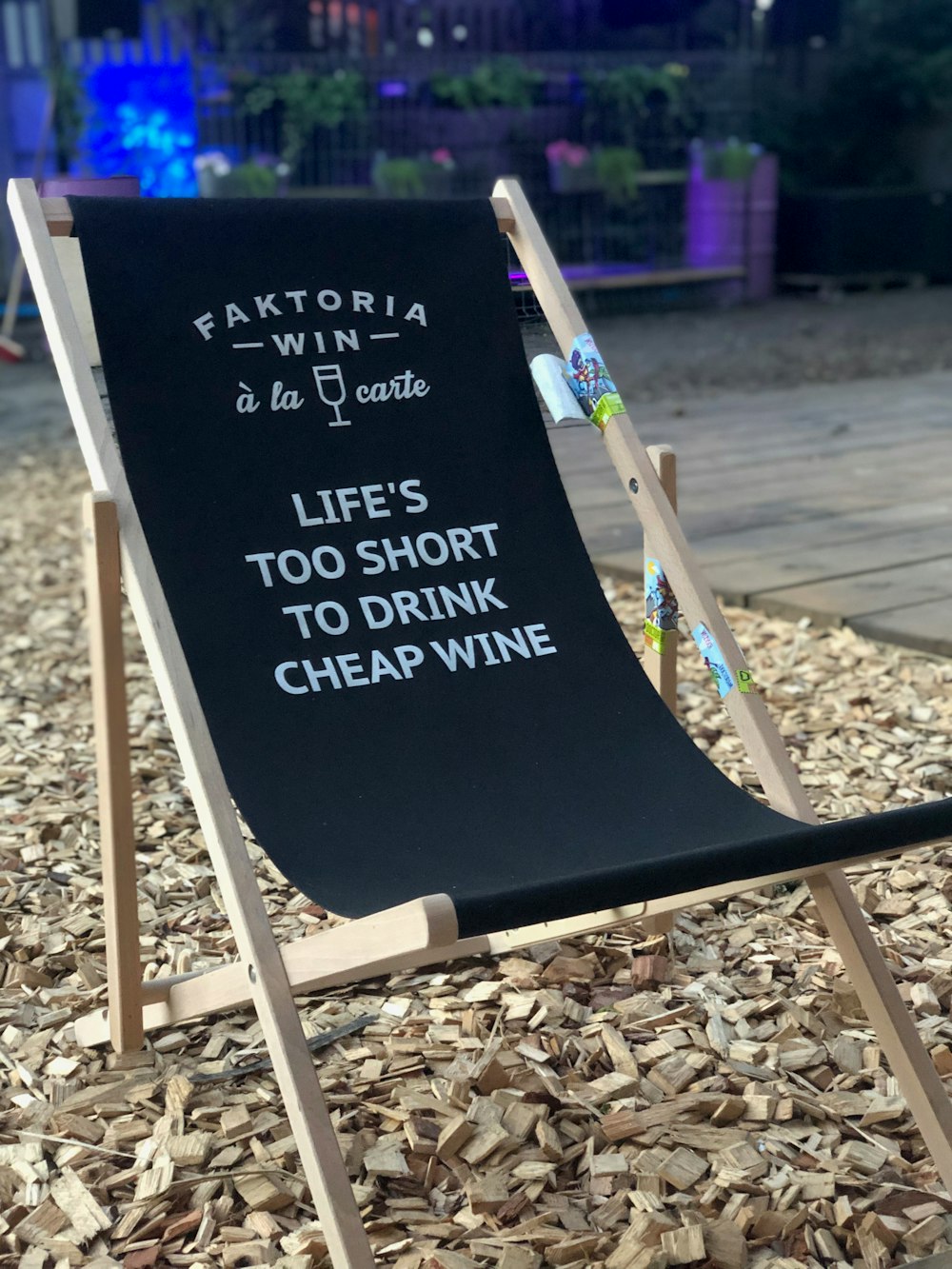 empty brown wooden framed camping chair on sand