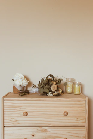 A bedroom dresser topped with framed photos and tasteful candles for a warm atmosphere.