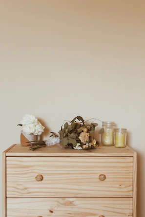 Refurbished antique dresser with distressed paint and a bouquet of dried wildflowers on top