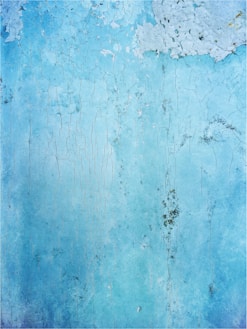 a blue wall with peeling paint on it