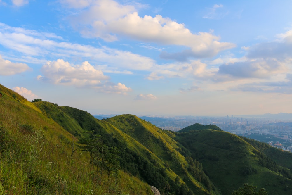 green mountain under white and blue cloudy sky