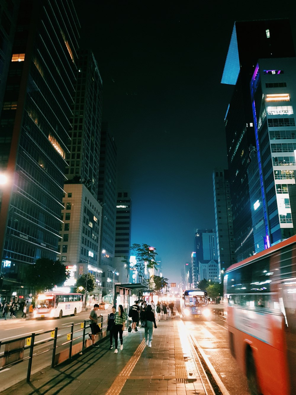 people walking on sidewalk during nighttime