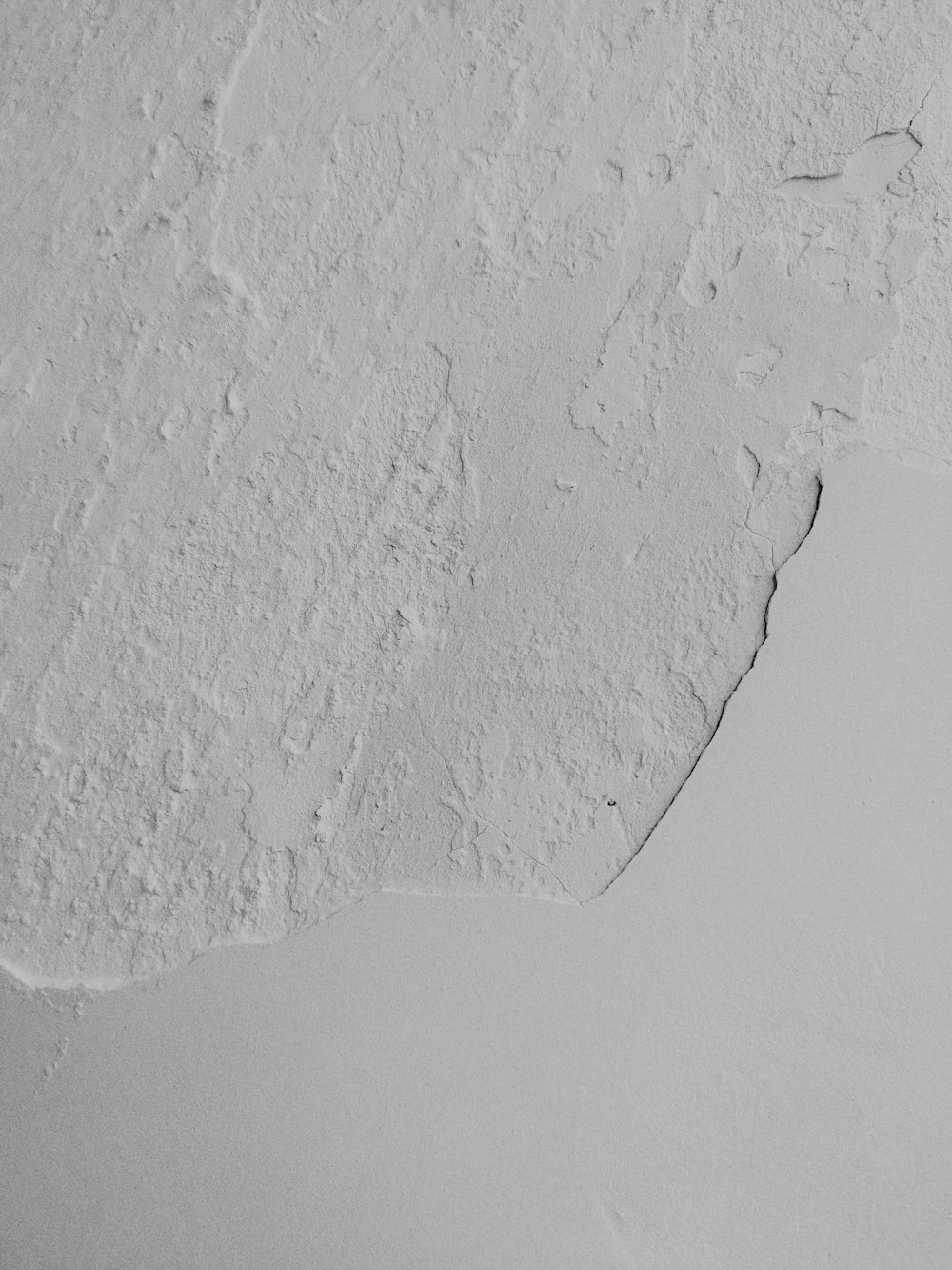 a white wall with a crack in the middle of it