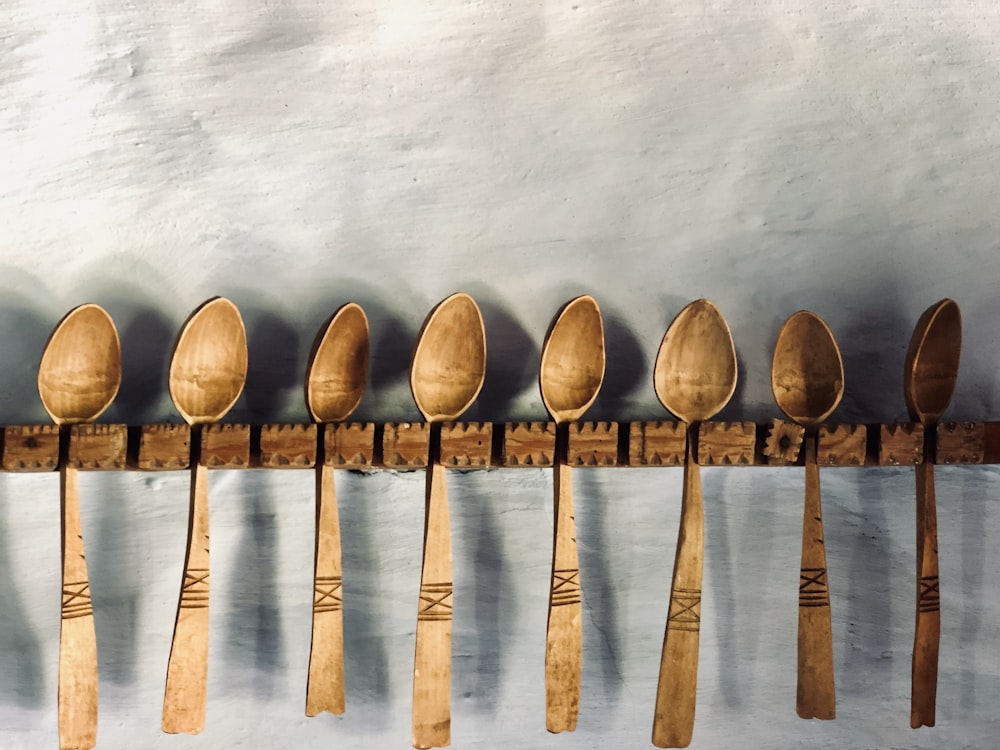 brown wooden spoons on wooden rack