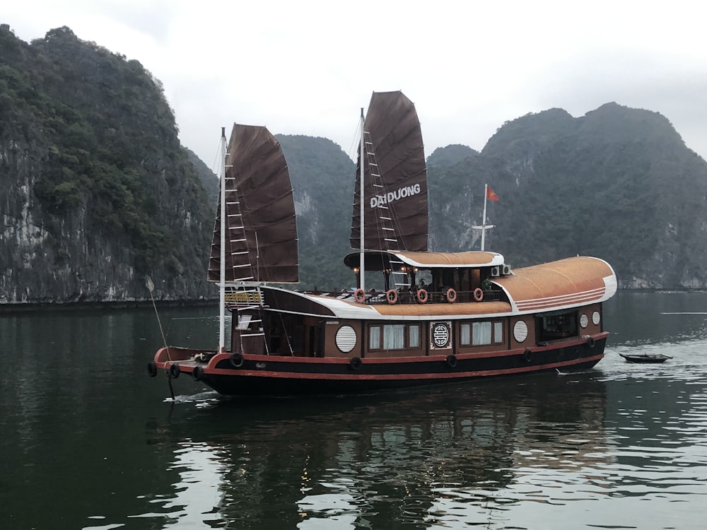 brown and white boat on body of water at daytime