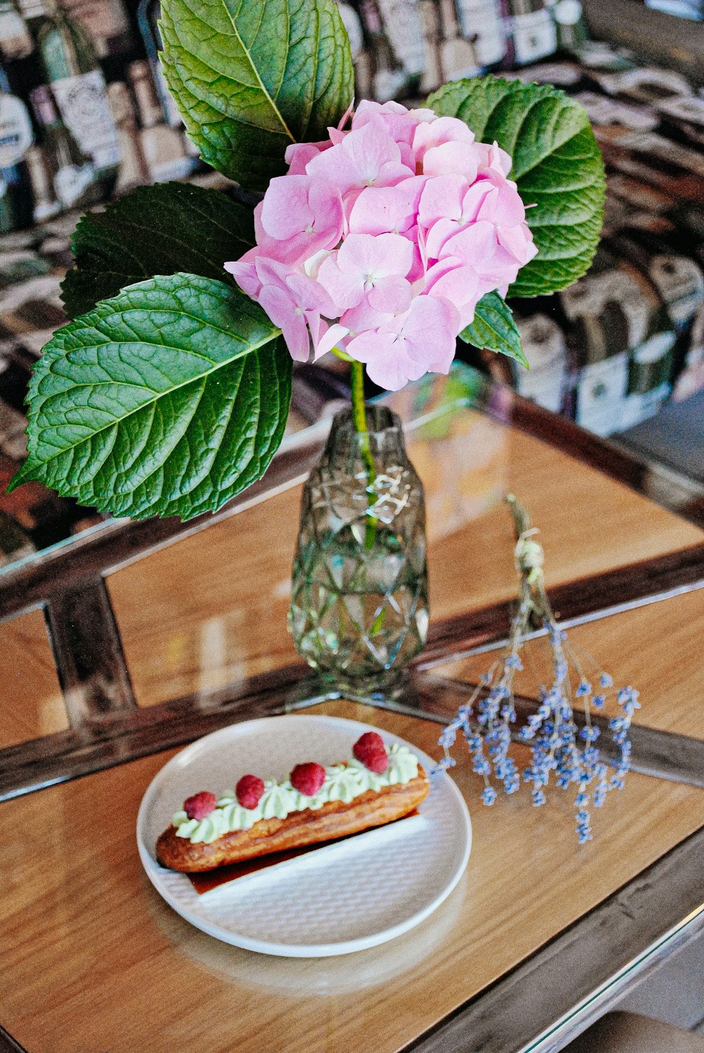 blooming pink hydrangea flower in glass vase on wooden table