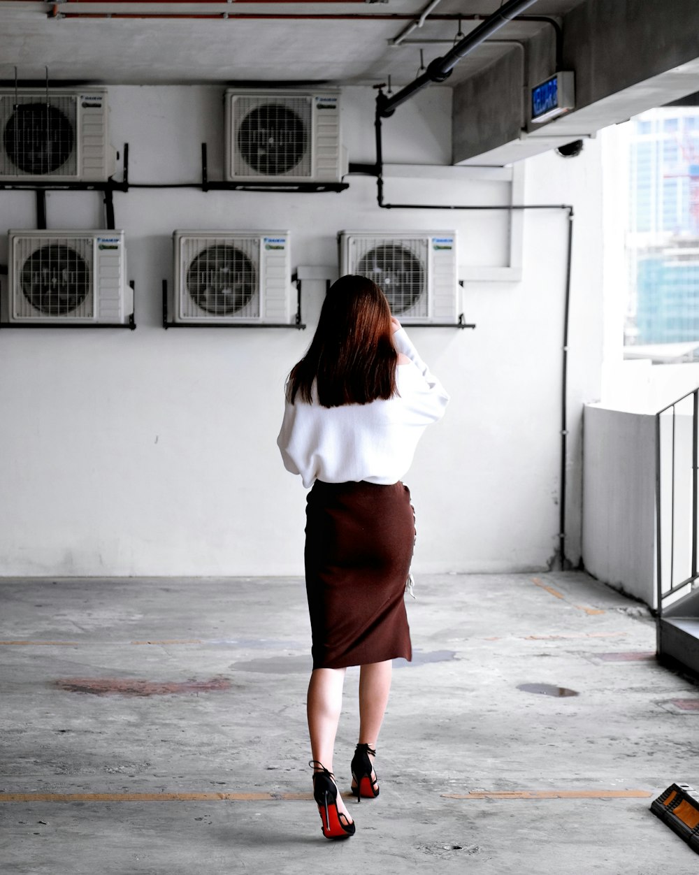 woman facing towards air condensers