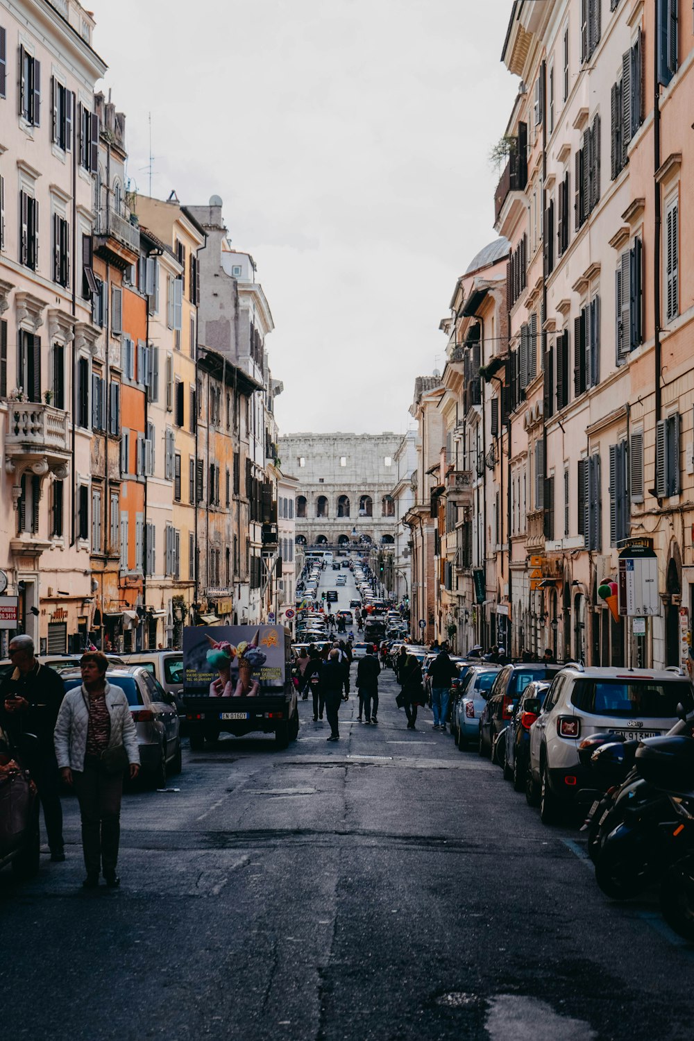 people standing between concrete buildings at daytime