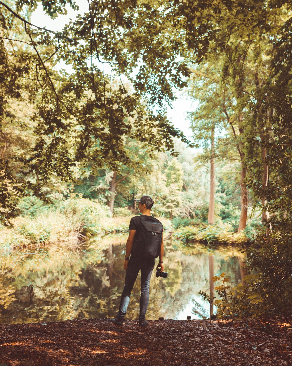 man standing near pond