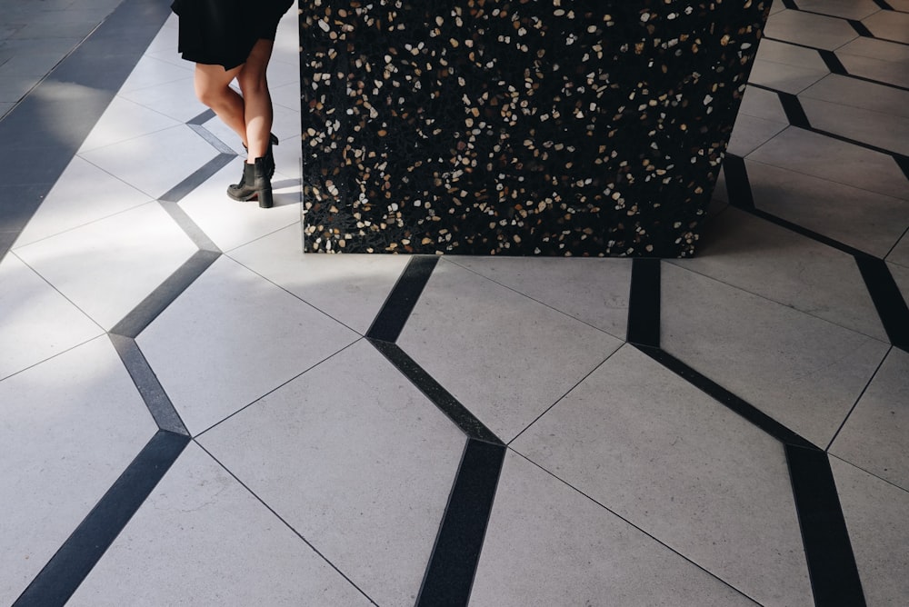 a woman standing next to a black and white counter